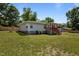 Side view of home with light gray siding, red porch, green lawn and landscaping at 670 Mcadams Rd, Hillsborough, NC 27278