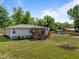 Beautifully landscaped yard with a cozy fire pit area, creating an inviting outdoor space for relaxing and entertaining at 670 Mcadams Rd, Hillsborough, NC 27278