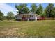 Charming home with a red porch and deck nestled in a green, tree filled, landscaped front yard at 670 Mcadams Rd, Hillsborough, NC 27278