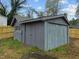 A gray outbuilding or storage shed is in the backyard with access from the side yard at 670 Mcadams Rd, Hillsborough, NC 27278