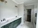 Bathroom featuring marble tile, double sink vanity with green cabinets, and a walk-in shower at 136 Bar Code Ct, Wendell, NC 27591