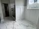 Bathroom featuring marble tile, white wainscoting, and a walk-in shower and closet at 136 Bar Code Ct, Wendell, NC 27591