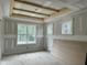 Bedroom featuring tray ceiling, three windows, and light gray walls at 136 Bar Code Ct, Wendell, NC 27591