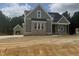 New construction two-story home featuring neutral siding and brickwork with a detached garage at 136 Bar Code Ct, Wendell, NC 27591