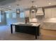 Bright kitchen featuring white cabinets, a large island with a sink, and modern pendant lighting at 136 Bar Code Ct, Wendell, NC 27591