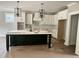 Bright kitchen with white cabinets, modern light fixtures, and large dark island at 136 Bar Code Ct, Wendell, NC 27591