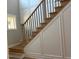 Elegant stairway with wooden treads, wrought iron balusters, and decorative wall molding provides a sophisticated touch at 136 Bar Code Ct, Wendell, NC 27591