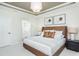 This bedroom features a brown leather headboard, minimalist artwork, and an ensuite bathroom at 2308 Beeblossom Pl, Fuquay Varina, NC 27526