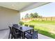 Covered patio with a black table and chairs, overlooking a lush green lawn and wooded perimeter at 2308 Beeblossom Pl, Fuquay Varina, NC 27526