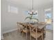Cozy dining area featuring a wooden table, seating for six, stylish light fixture, and ample natural light at 2317 Forsythia Trl, Fuquay Varina, NC 27526
