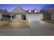 Stylish home with a well-lit driveway and landscaped front yard during twilight, showcasing its curb appeal at 2317 Forsythia Trl, Fuquay Varina, NC 27526