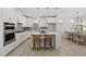 Well-appointed kitchen featuring white cabinets, stainless steel appliances, and a kitchen island with bar stools at 2317 Forsythia Trl, Fuquay Varina, NC 27526