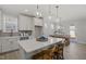 Bright kitchen with white cabinetry, a large island with seating, pendant lighting, and an adjacent dining area at 2317 Forsythia Trl, Fuquay Varina, NC 27526