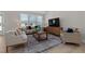 Bright living room with a neutral color palette, large windows, a comfortable sofa, and stylish furniture at 2317 Forsythia Trl, Fuquay Varina, NC 27526