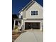 New construction home featuring a two-car garage and a covered porch, with a combination of siding and stone accents at 2476 Field Poppy Dr # 171, Apex, NC 27502