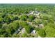 An aerial view of a town with mature trees with homes, commercial buildings and a green playing field at 320 W Orange St, Hillsborough, NC 27278