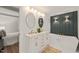 Luxurious bathroom with dual vanity, gold fixtures, soaking tub, and modern lighting at 320 W Orange St, Hillsborough, NC 27278