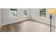 Bright bedroom features three windows, neutral walls, and beautiful hardwood floors at 320 W Orange St, Hillsborough, NC 27278