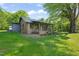 Charming brick home with a welcoming porch, wrought iron railings, and lush greenery surrounding the property at 320 W Orange St, Hillsborough, NC 27278