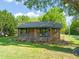 Inviting brick home with a covered porch, complete with hanging flower baskets and a tree swing in the yard at 320 W Orange St, Hillsborough, NC 27278