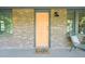 Close up of the front porch with peach colored front door, brick exterior, and view of seating area at 320 W Orange St, Hillsborough, NC 27278