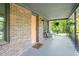 Charming front porch with brick accents, cozy seating, and hanging plants, perfect for relaxing outdoors at 320 W Orange St, Hillsborough, NC 27278