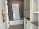 A new bathroom with gray tile walls, white fixtures and a combined shower and bathtub at 71 Slocum Dr, Wendell, NC 27591