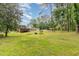 Green backyard with a home and covered area to relax at 129 Jeffress Dr, Louisburg, NC 27549