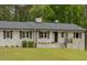 Charming ranch home with a painted brick facade, complemented by black shutters and a well-manicured lawn at 129 Jeffress Dr, Louisburg, NC 27549