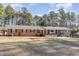 Brick ranch house with stone accents, large yard, and mature trees at 129 Jeffress Dr, Louisburg, NC 27549