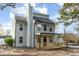 Gray home with a striking chimney, large windows, and covered front porch, set against a blue sky at 182 Sierra Trl, Spring Lake, NC 28390
