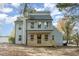 Charming gray home with a covered porch, a black front door, and bright windows under a blue, partly cloudy sky at 182 Sierra Trl, Spring Lake, NC 28390