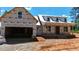 Unfinished exterior of a house with a two-car garage and dormer windows under a clear blue sky at 2850 Sheep Pasture Rd, Spring Hope, NC 27882
