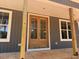 Wooden double front door framed by large windows and gray siding at 2850 Sheep Pasture Rd, Spring Hope, NC 27882