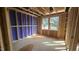 Unfinished bedroom featuring stud framing, plywood subfloor, two windows offering natural light, and exposed roof rafters at 3934 Well Fleet Drive, Fuquay Varina, NC 27526