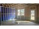 An unfinished room featuring windows and an exterior door, ready for customization at 3934 Well Fleet Drive, Fuquay Varina, NC 27526