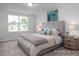 Bright bedroom features a plush bed, neutral decor and a view of the neighborhood at 3934 Well Fleet Drive, Fuquay Varina, NC 27526