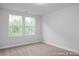 This bedroom has carpet flooring, is painted in light colors, and has two windows at 3934 Well Fleet Drive, Fuquay Varina, NC 27526