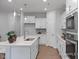 Bright kitchen featuring an island with seating, stainless steel appliances, and white cabinetry at 3934 Well Fleet Drive, Fuquay Varina, NC 27526