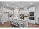 Modern kitchen with stainless appliances, white cabinetry and a large center island with seating at 3934 Well Fleet Drive, Fuquay Varina, NC 27526