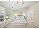 Bright bedroom with a large window, ceiling fan, neutral carpet, and ensuite bathroom at 418 Bergen Ave, Apex, NC 27502