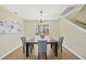 Cozy dining room with modern chandelier, wood table, and four comfortable gray chairs at 418 Bergen Ave, Apex, NC 27502