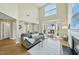 Bright living room with high ceilings, large windows, fireplace, and cozy gray sofa at 418 Bergen Ave, Apex, NC 27502