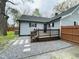 Backyard with gravel, deck, wooden fence and gray siding with black trim at 1003 W Anderson St, Selma, NC 27576