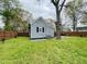 Backyard showing gray siding, wooden fence, air conditioner and grassy lawn at 1003 W Anderson St, Selma, NC 27576