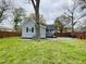 Backyard view features fence, shed, gray siding and grassy lawn at 1003 W Anderson St, Selma, NC 27576
