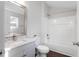 Bathroom with white tiled shower, gray vanity with granite counter, and framed mirror at 1003 W Anderson St, Selma, NC 27576