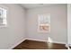 Cozy bedroom with hardwood-style flooring, two bright windows, and fresh neutral paint at 1003 W Anderson St, Selma, NC 27576