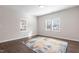 Bright bedroom featuring two windows, neutral walls, and wood-look flooring with an area rug at 1003 W Anderson St, Selma, NC 27576