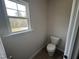 An unfinished half-bath offers neutral walls and a large window overlooking a wooded lot at 165 Knoll Way, Sanford, NC 27332